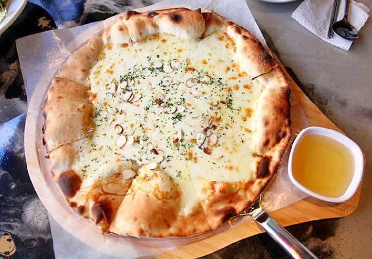 Gorgonzola pizza fresh from the oven at Hwa Tteok, with a delicious blend of cheese, almonds, and herbs served with honey.